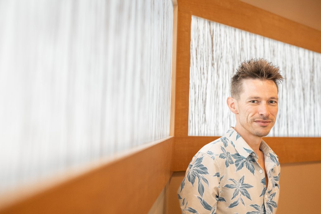 Photo of a man wearing a blue flowered shirt.