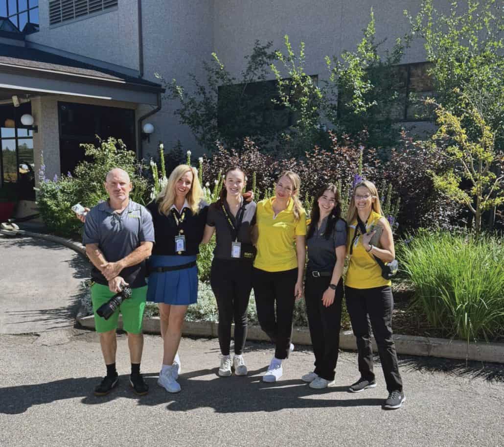 Six people part of a golf team standing together.