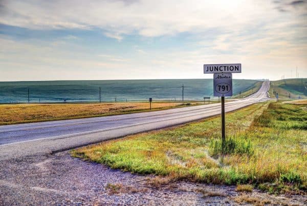 Stretch of a highway with green grass.