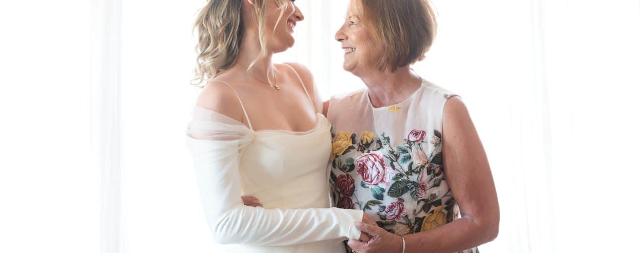 Mother and daughter look at each lovingly on the daughter's wedding day.