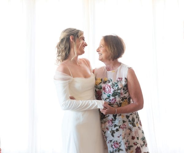 Mother and daughter look at each lovingly on the daughter's wedding day.