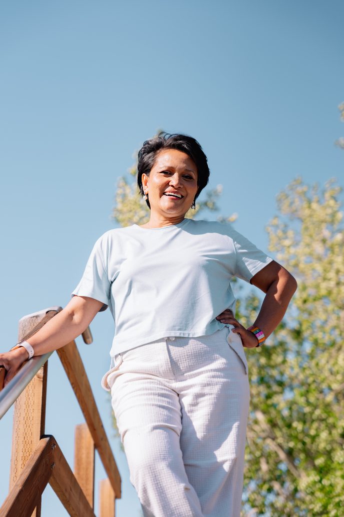 Photo of a woman in white with a blue sky behind her.
