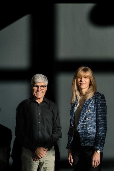 Man and women standing looking at the camera with the sun shining on them.