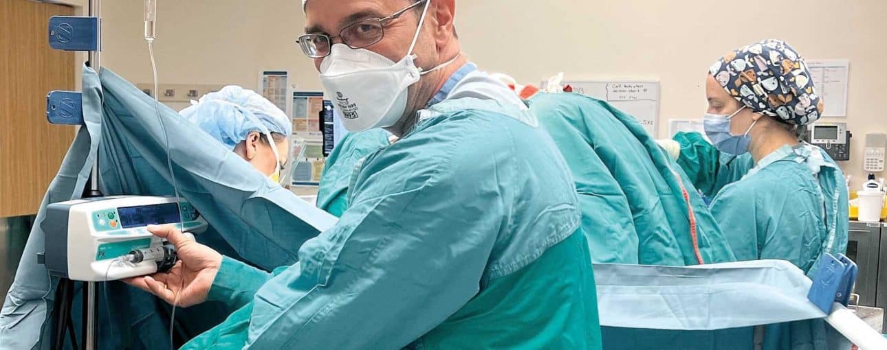Anesthesiologist in blue scrubs in the operating room.