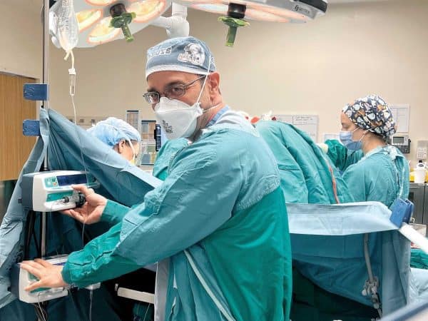 Anesthesiologist in blue scrubs in the operating room.