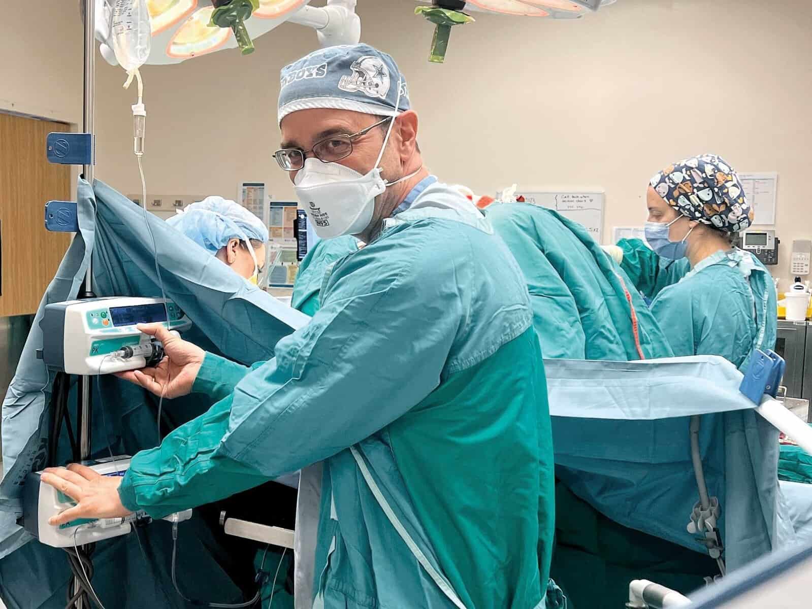 Anesthesiologist in blue scrubs in the operating room.