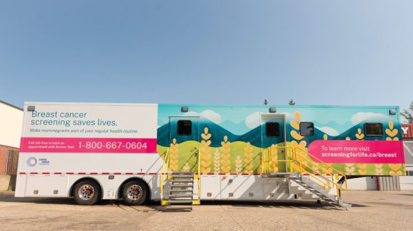 The exterior of a mobile screening unit - a trailer painted with a an image of a canola field.