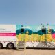 The exterior of a mobile screening unit - a trailer painted with a an image of a canola field. 