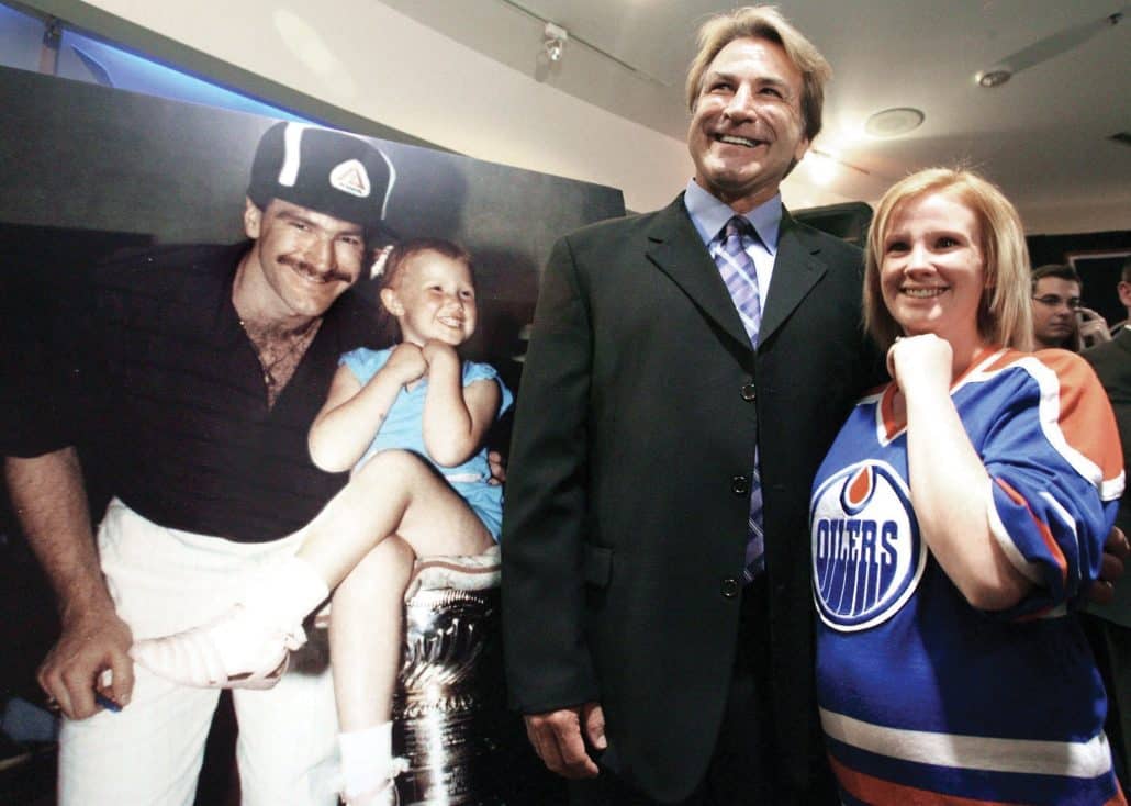 Hockey star Glenn Anderson poses with fan in an Oilers jersey. 