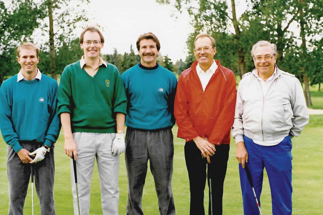 Image of Glenn Anderson standing on the green next to other golfers. 