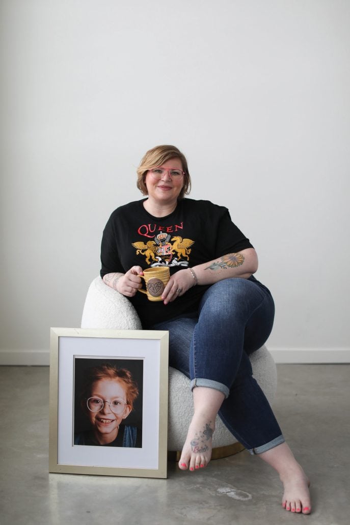 Woman sits next to a picture of her late daughter. 