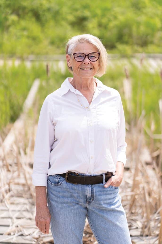 Woman in white smiling and looking into the camera. 