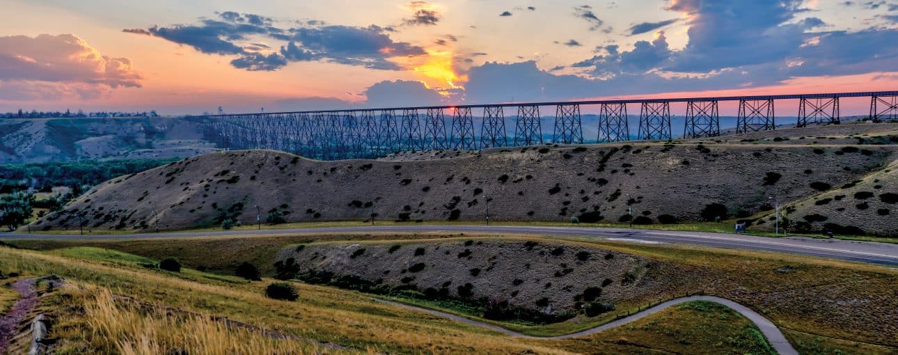 Scenic view of a bridge, roads and fields with a colourful sunset.