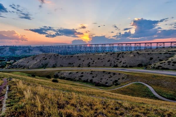 Scenic view of a bridge, roads and fields with a colourful sunset.