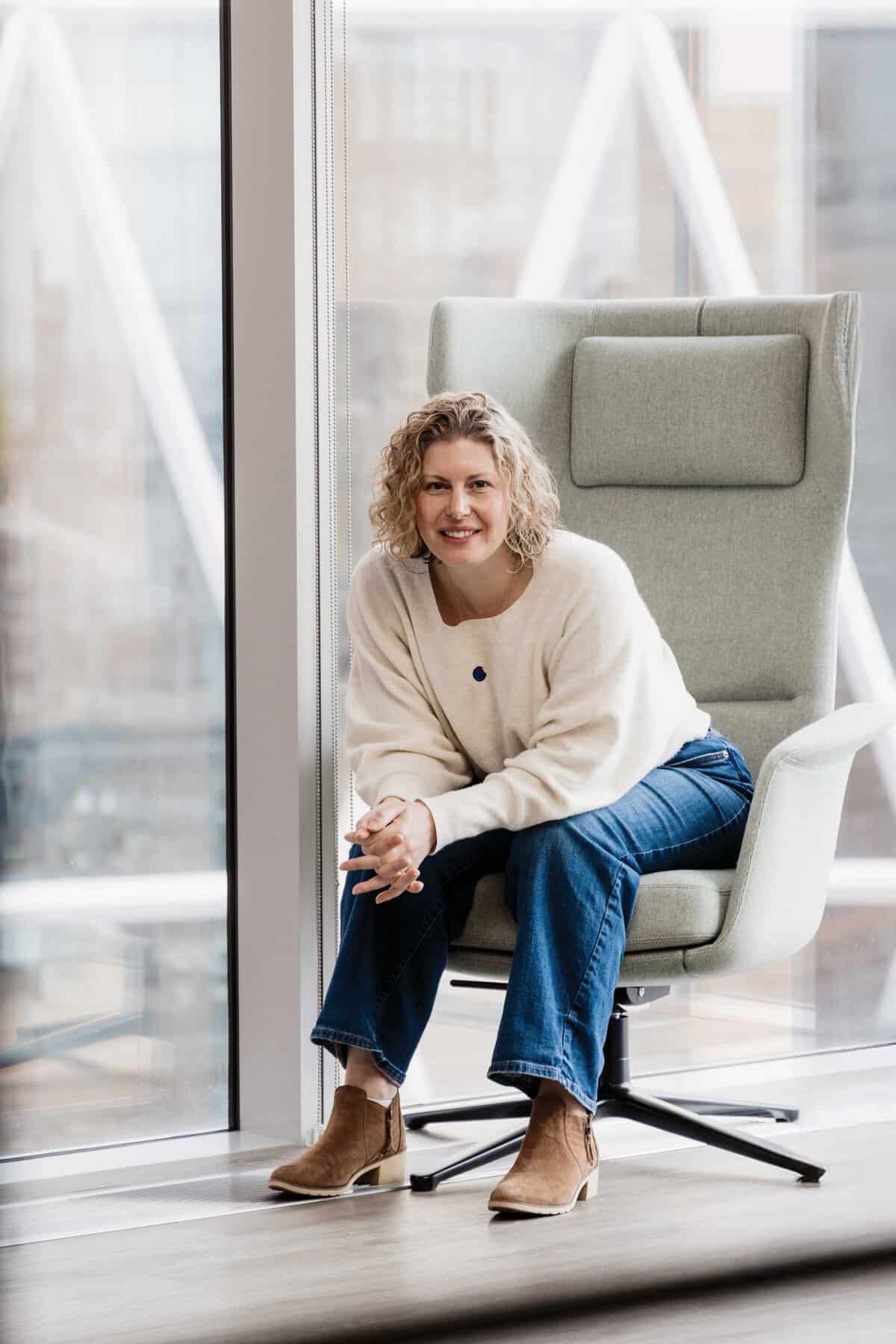 Woman in a white sweater sitting in a large charge. 