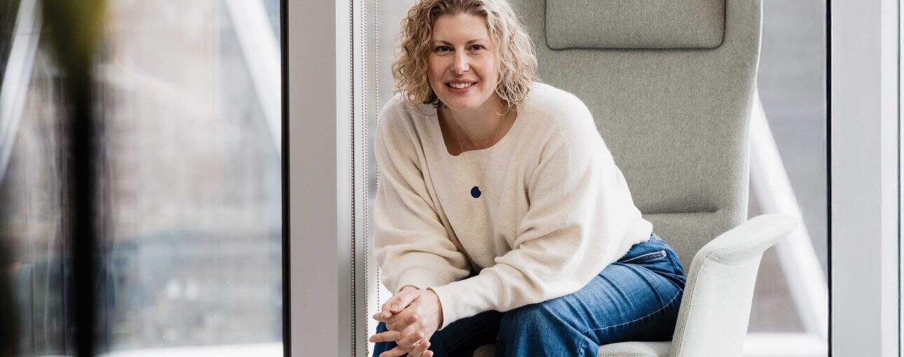 Woman in a white sweater sitting in a large charge.