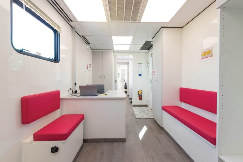The interior of the unit with pink seating and clean, white walls and surfaces.