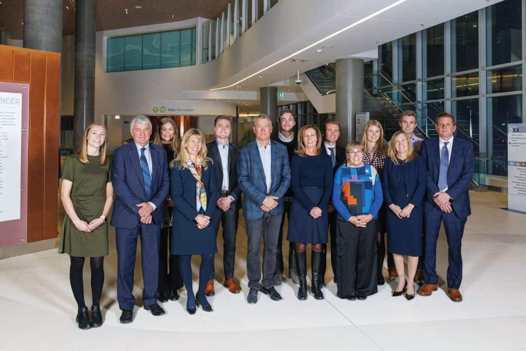 Fourteen members of the Riddell family stand together.