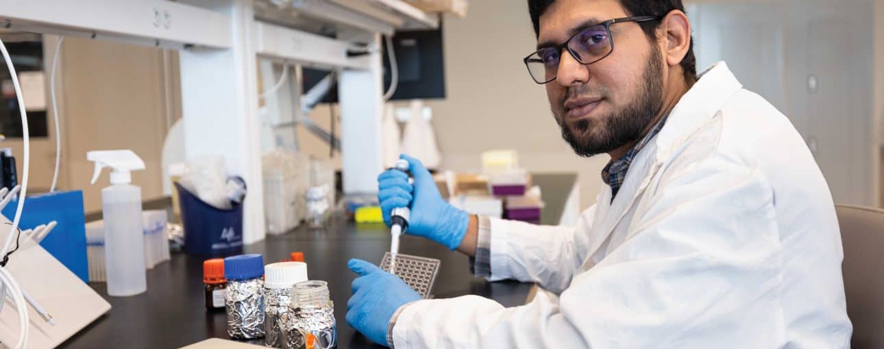 Researcher in white lab coat.