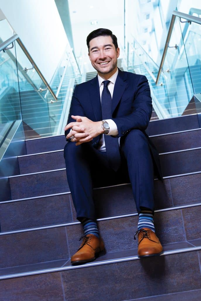 Man in blue suit sitting on stairs.